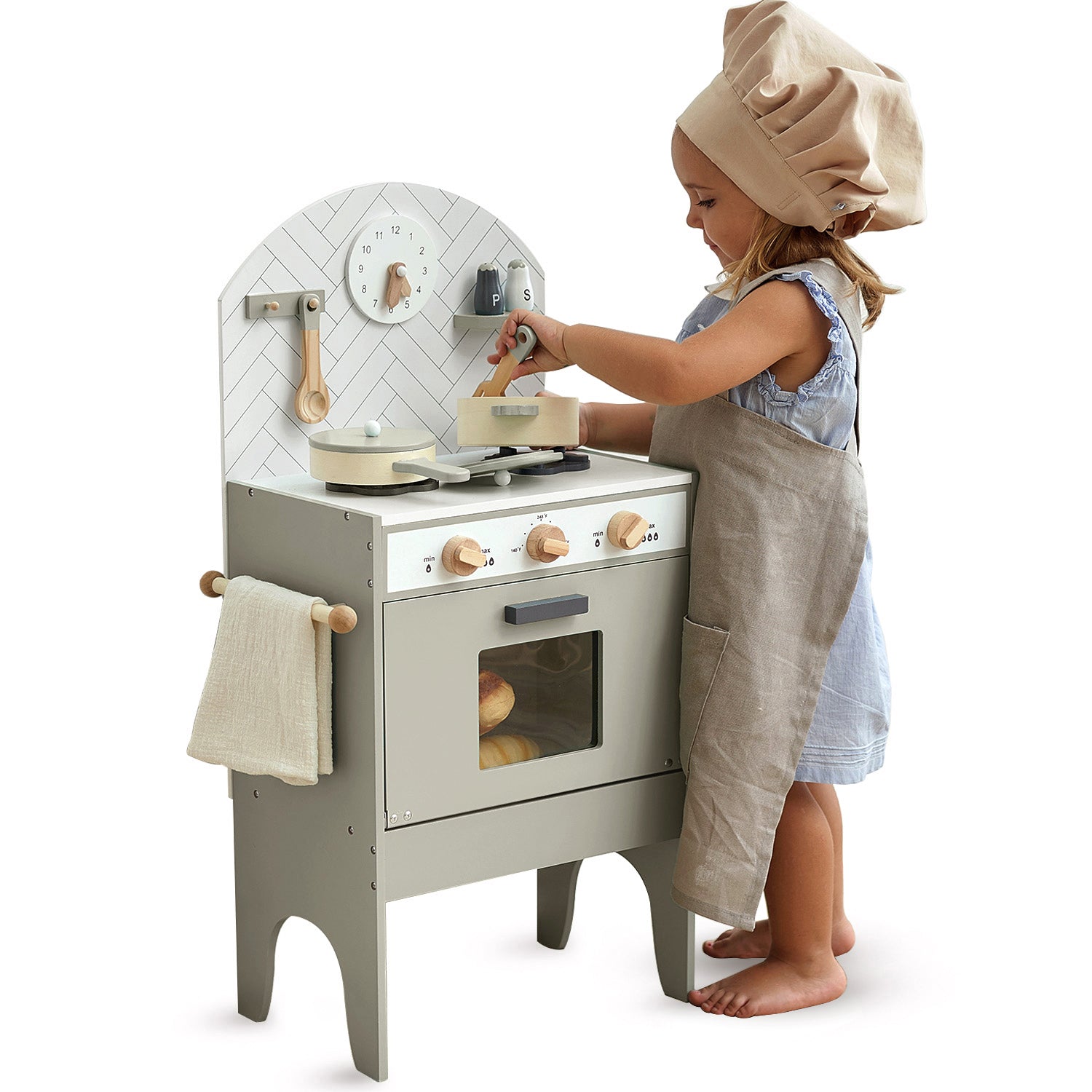 Child playing with a classic toy kitchen set on a white background