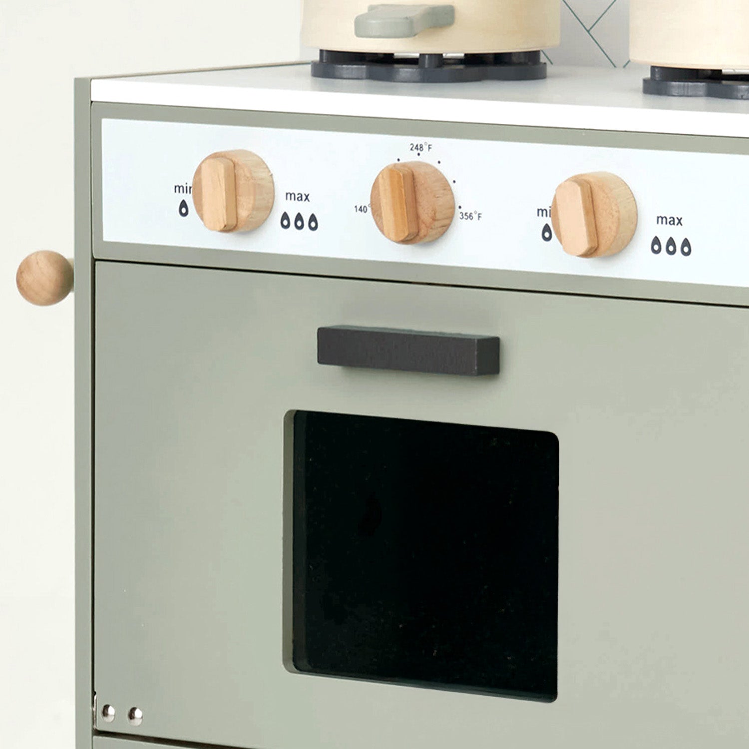 Children's toy kitchen oven with wooden knobs on a white background