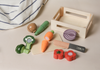 Realistic painted wooden vegetables with a toy knife and basket, perfect for sorting and pretend play.